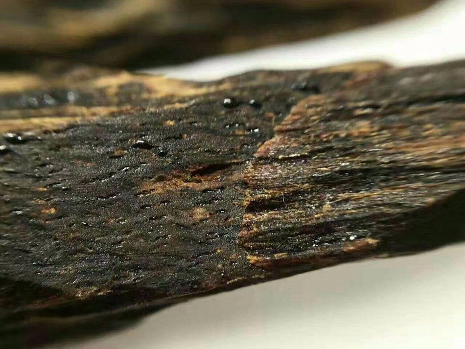 قطعة عود كيارا داكنة تظهر عليها خطوط الراتنج